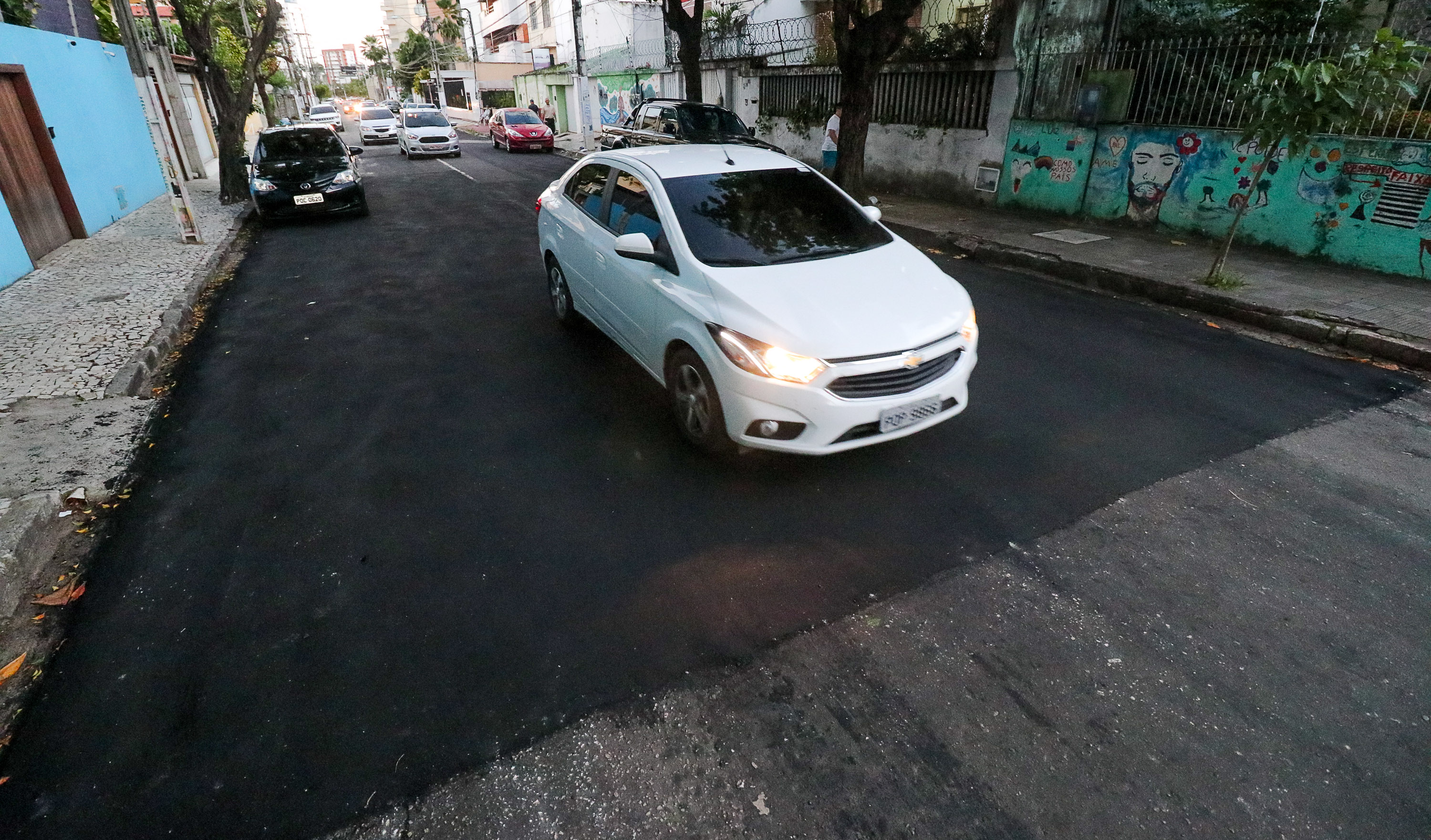 carro passa por rua que recebeu asfalto recentemente